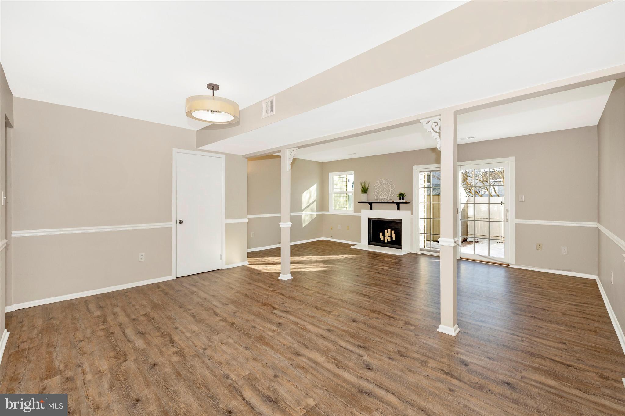 17513 Hoskinson Road Poolesville, MD 20837 - Photo 12 of 44 an empty room with wooden floor and fireplace