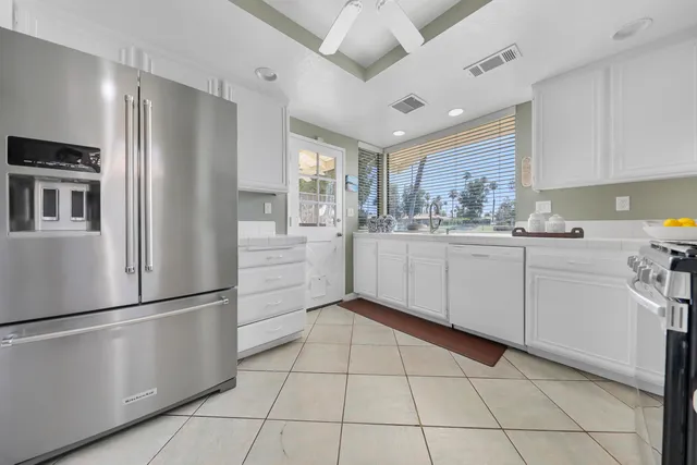 a kitchen with white cabinets appliances and sink