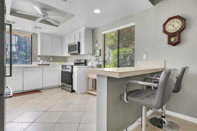 a open dining room with stainless steel appliances furniture a window and kitchen view