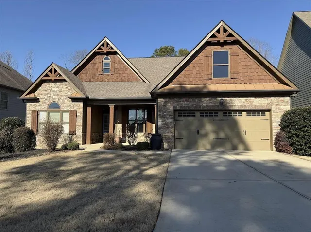 a front view of a house with yard and glass windows