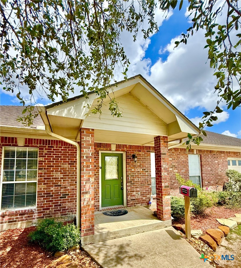 415 South Trinity Street Edna, TX 77957 - Photo 4 of 46 a view of a brick house with a large windows and a large tree