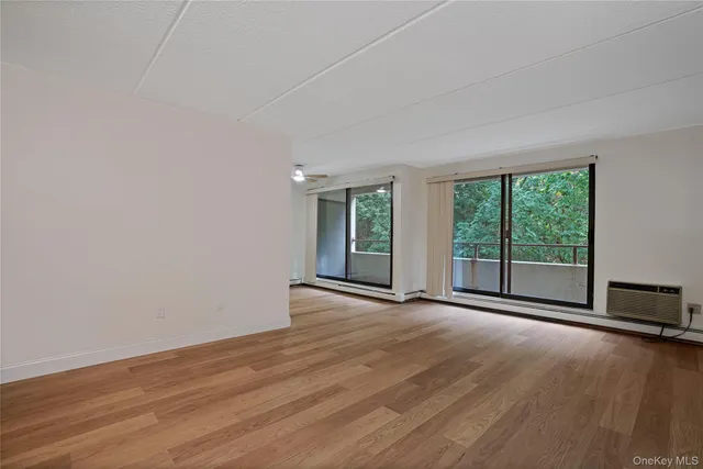 a view of a room with wooden floor and a window