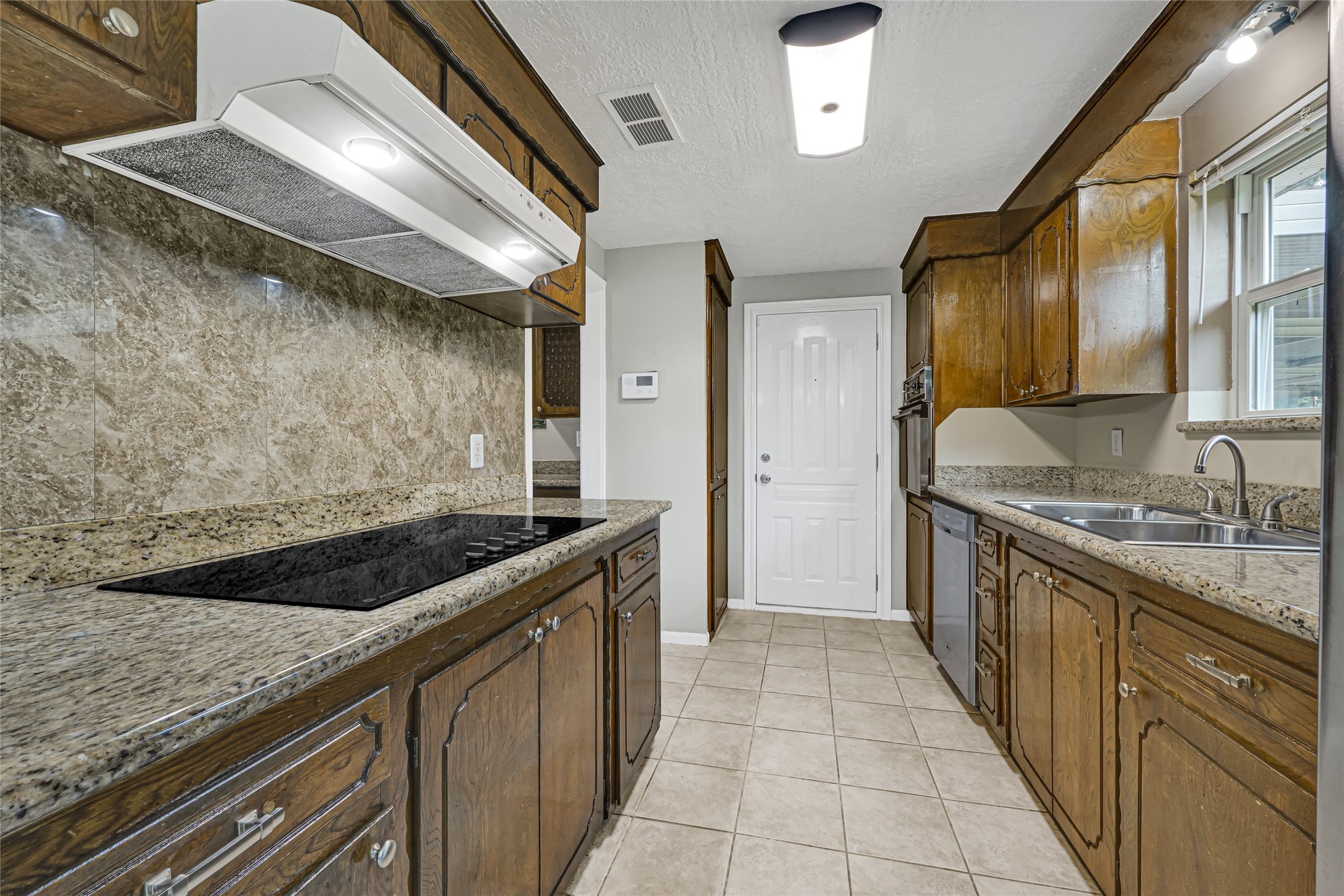 20135 Timber Line Lane New Caney, TX 77357 - Photo 13 of 30 a kitchen with granite countertop a sink and a stove