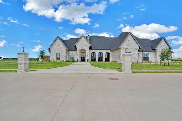 a view of a house with a big yard and large trees
