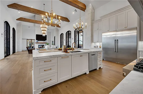a open kitchen with stainless steel appliances granite countertop a barbecue grill and view of living room