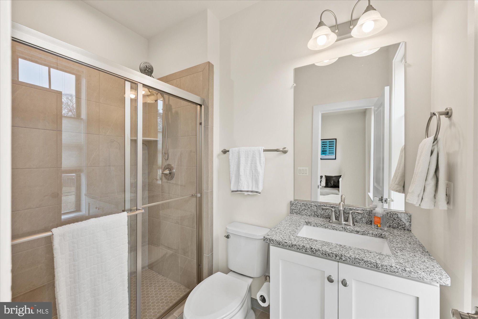 2236 South Glebe Road Arlington, VA 22206 - Photo 16 of 19 a bathroom with a granite countertop sink toilet and shower