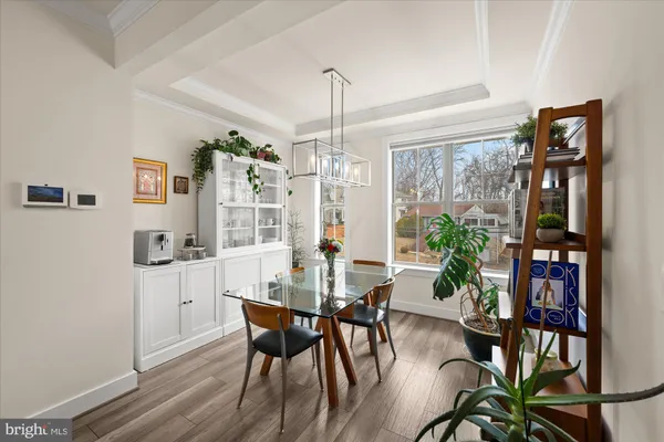 a dining room with furniture potted plants and wooden floor