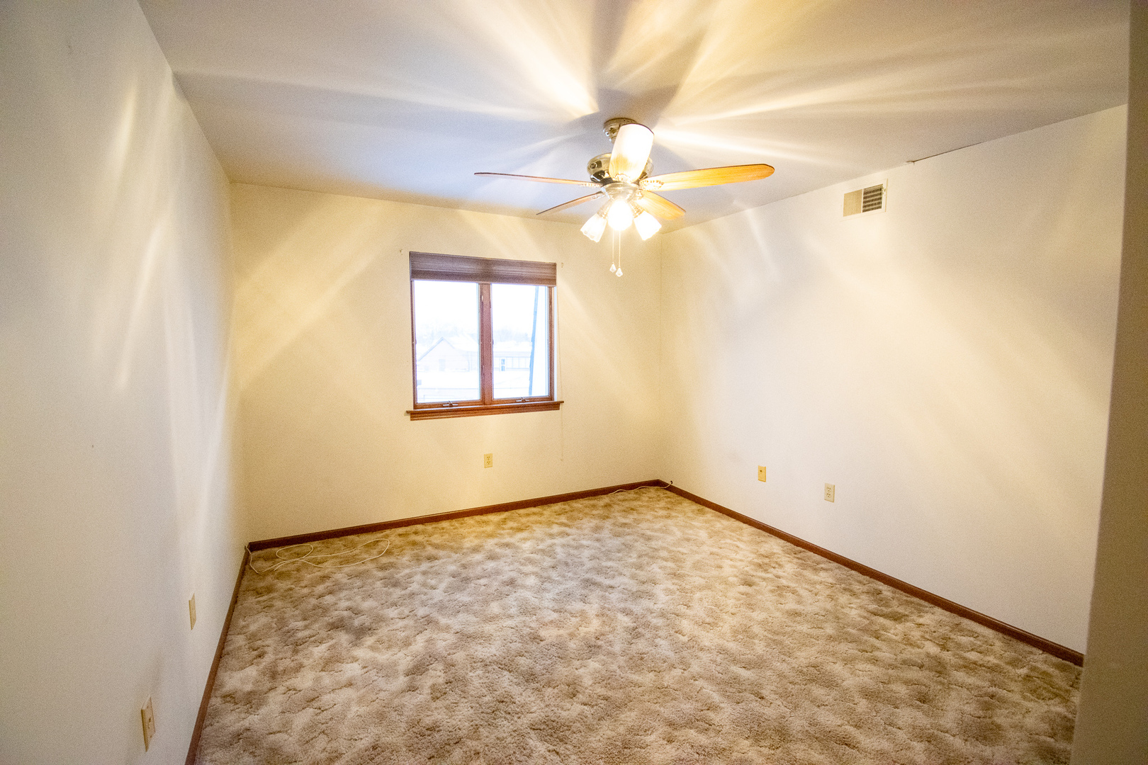 18300 Myrtle Court, Unit 3A Lansing, IL 60438 - Photo 10 of 20 an empty room with a chandelier fan and a window
