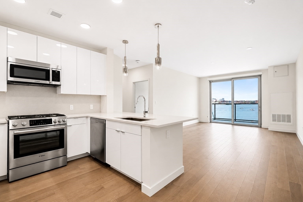 a kitchen with stainless steel appliances granite countertop a stove a sink and a microwave