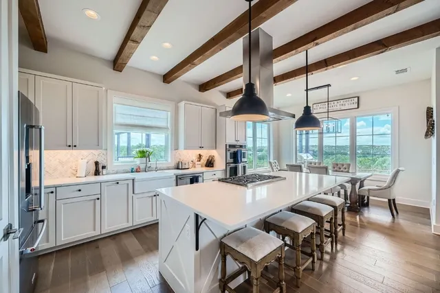 a large kitchen with a table chairs and wooden floor