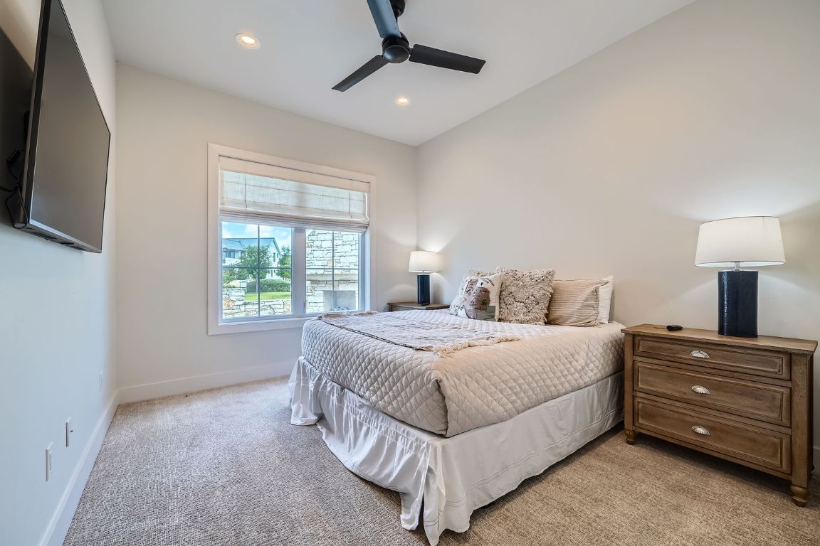 19517 Flying J Boulevard, Unit 8 Spicewood, TX 78669 - Photo 20 of 29 a bedroom with a bed and a tv