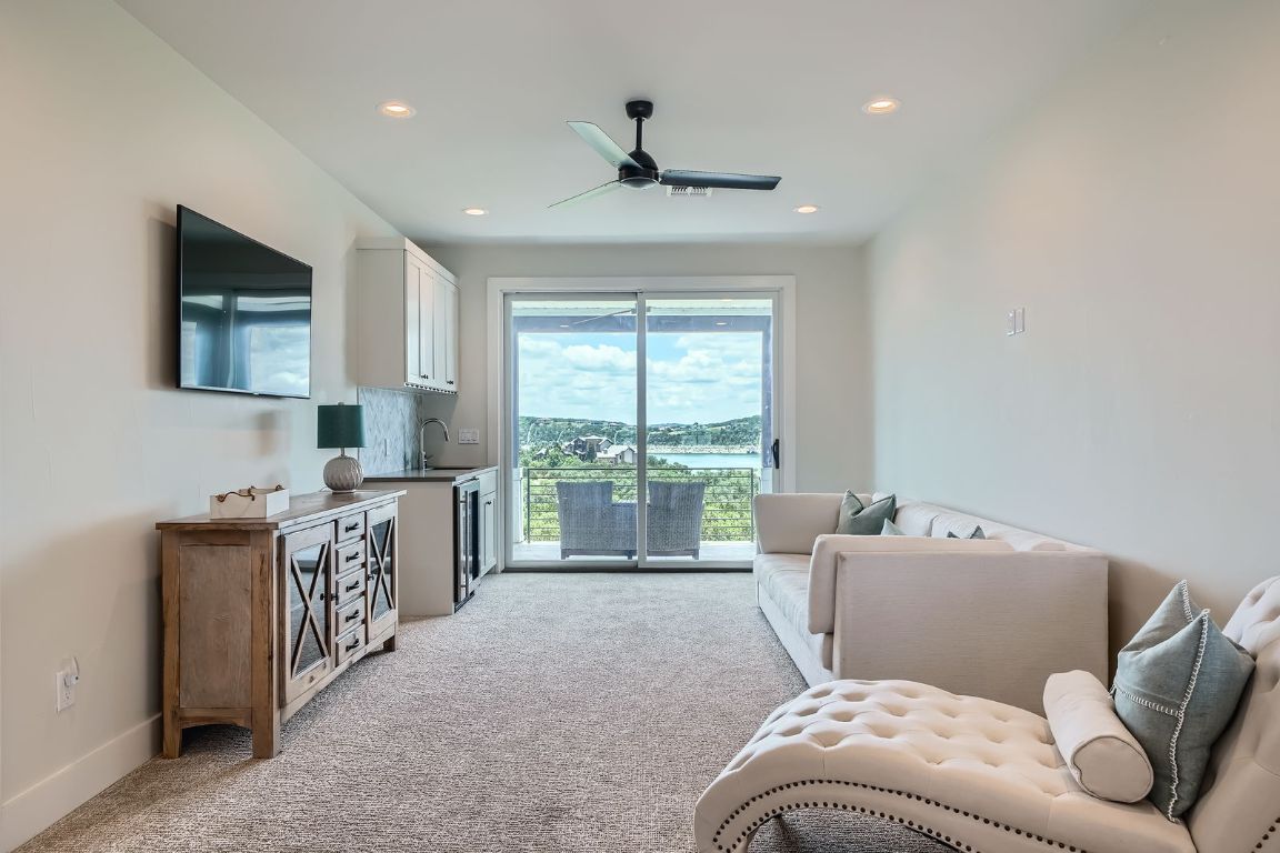 19517 Flying J Boulevard, Unit 8 Spicewood, TX 78669 - Photo 25 of 29 a living room with furniture and a flat screen tv