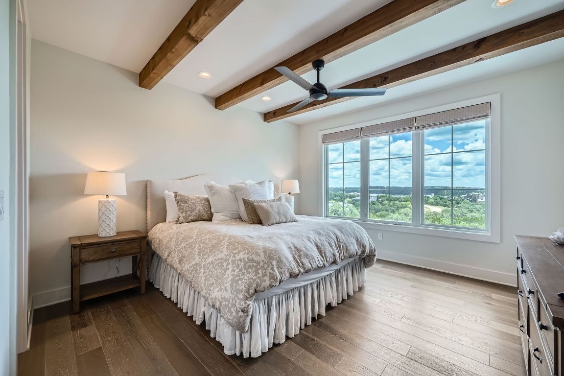 19517 Flying J Boulevard, Unit 8 Spicewood, TX 78669 - Photo 26 of 29 a bedroom with bed and a large window