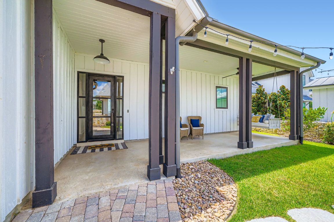 19517 Flying J Boulevard, Unit 8 Spicewood, TX 78669 - Photo 4 of 29 a view of a porch with a table and chairs and floor to ceiling window