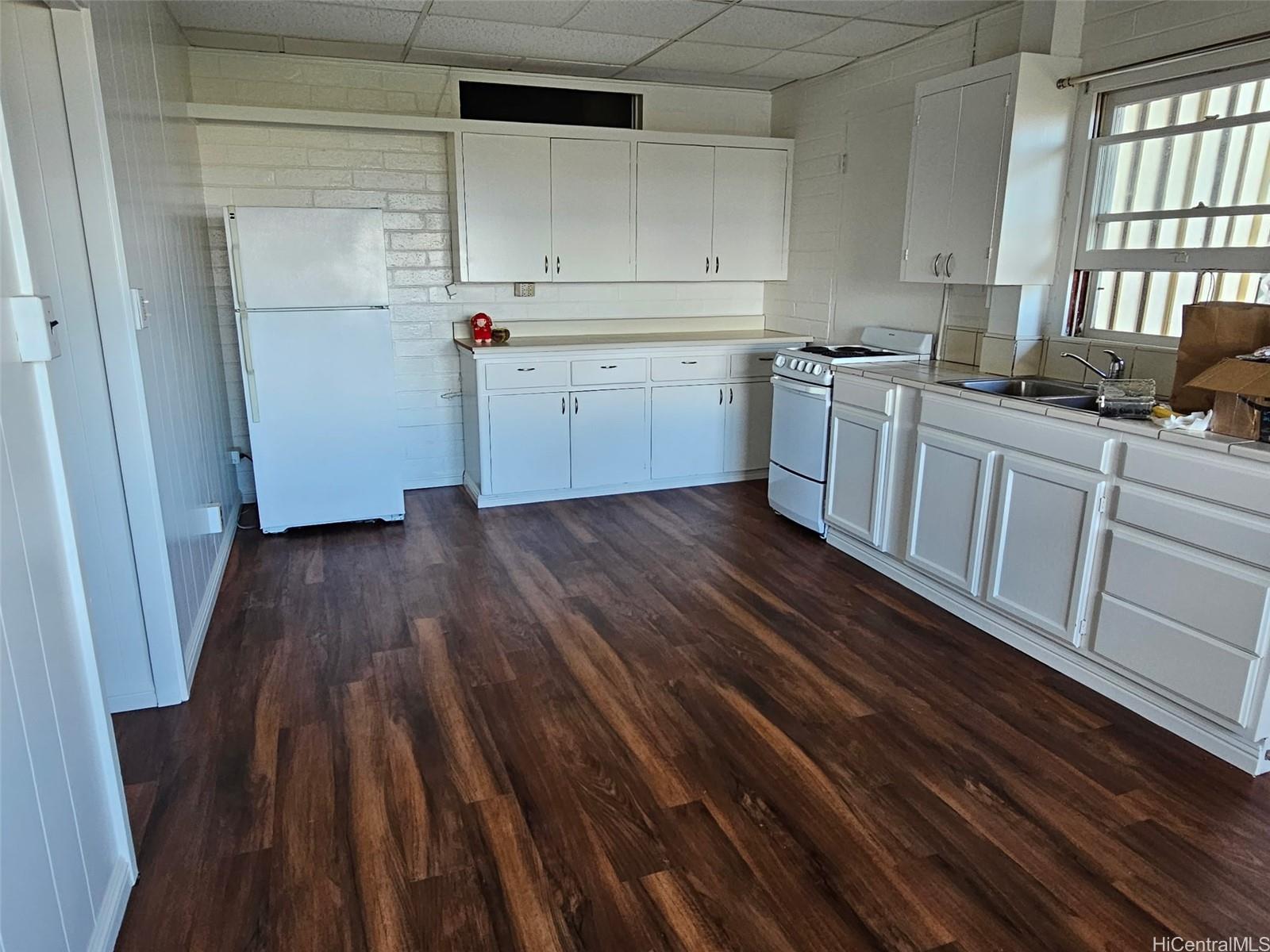 146 Prospect Street, Unit B Honolulu, HI 96813 - Photo 1 of 4 a kitchen with wooden floors and white cabinets