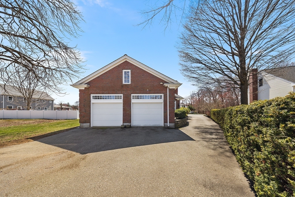 23 Landers Road Stoneham, MA 02180 - Photo 37 of 42 a front view of a house with a yard and garage