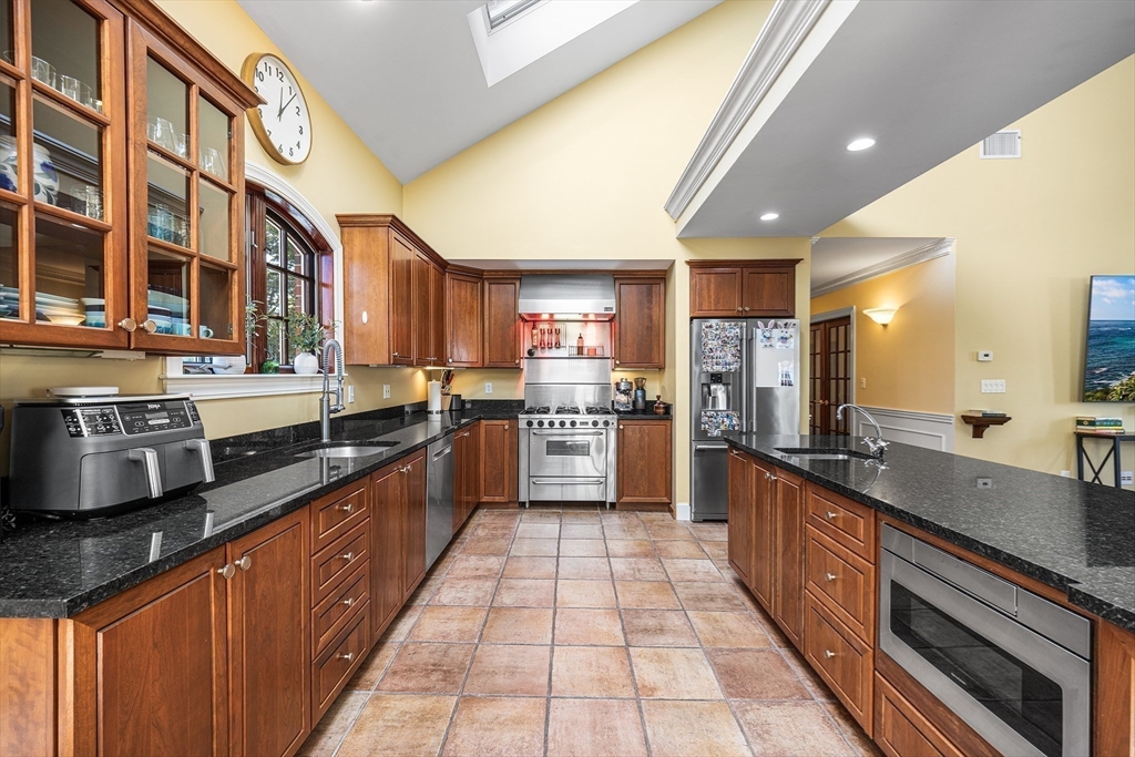 23 Landers Road Stoneham, MA 02180 - Photo 6 of 42 a large kitchen with stainless steel appliances granite countertop a large stove a sink dishwasher and cabinets with wooden floor