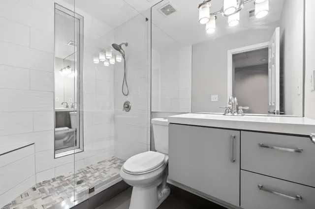 a bathroom with a sink a toilet and shower
