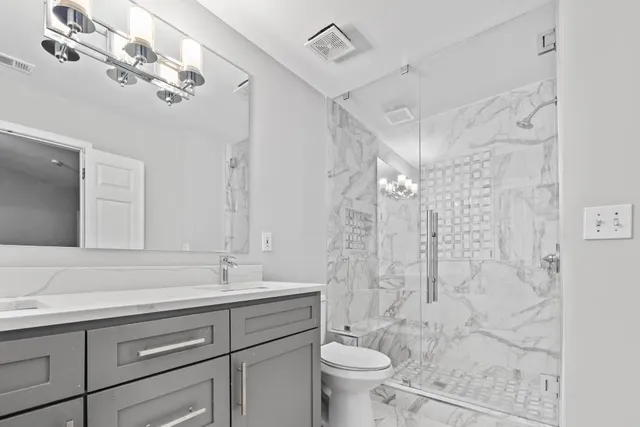 a bathroom with a sink a toilet and shower