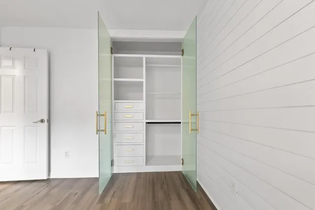 a view of walk in closet with empty racks