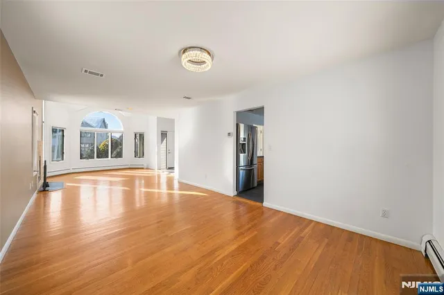 a large kitchen with stainless steel appliances granite countertop a lot of counter space and wooden floors