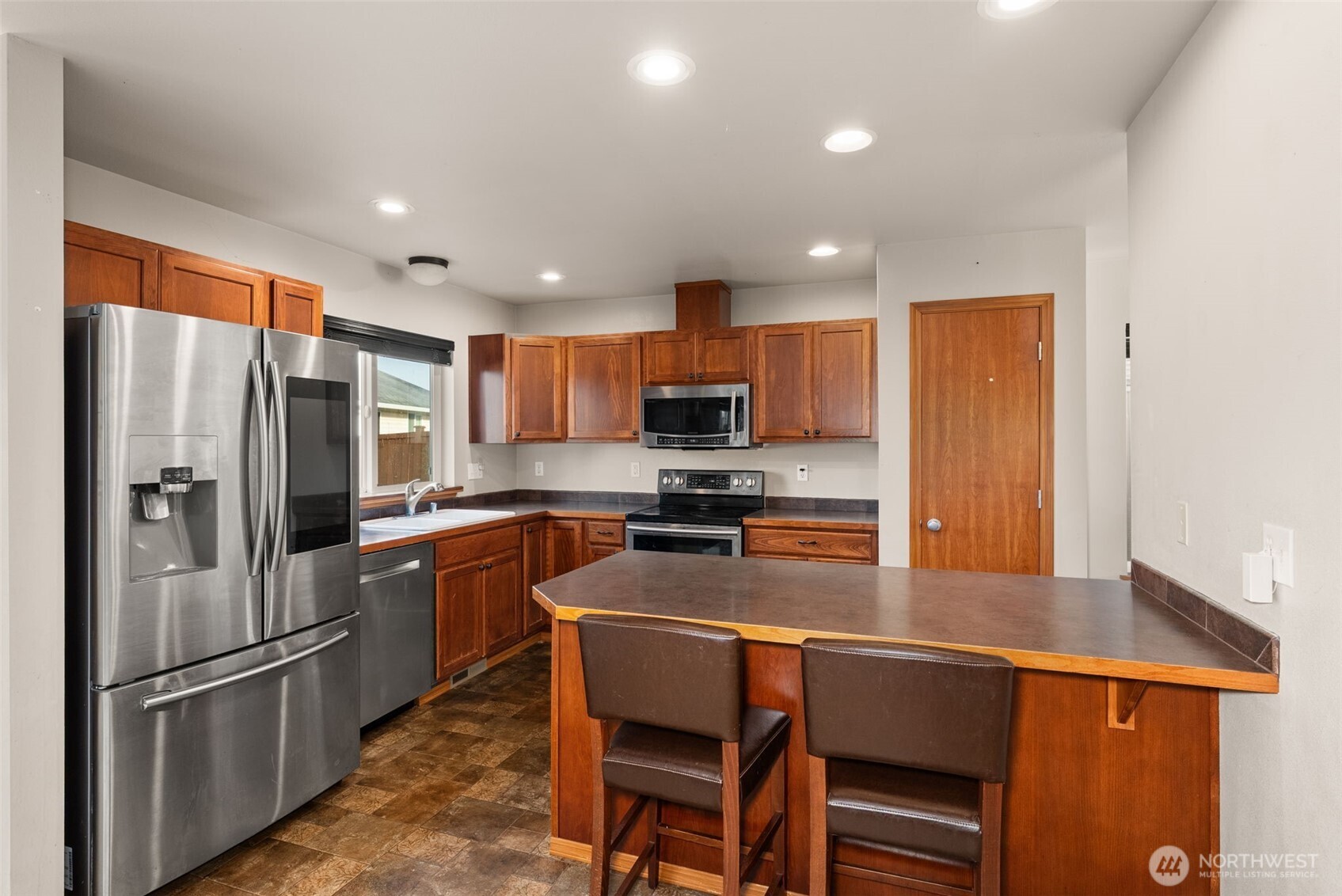 234 Wind River Drive Chehalis, WA 98532 - Photo 10 of 33 a kitchen with stainless steel appliances granite countertop a refrigerator a stove a sink a oven with a dining table and chairs