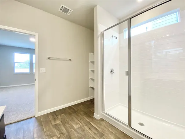 a bathroom with a glass shower door and a bathtub