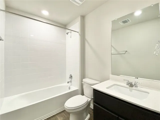 a bathroom with a sink a toilet a mirror and shower