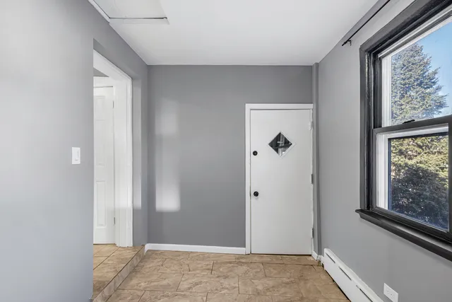 a view of a hallway with wooden floor and a bathroom