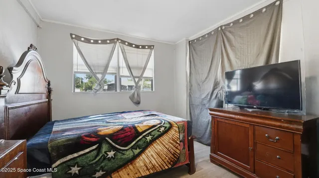 a bedroom with a bed and a flat screen tv