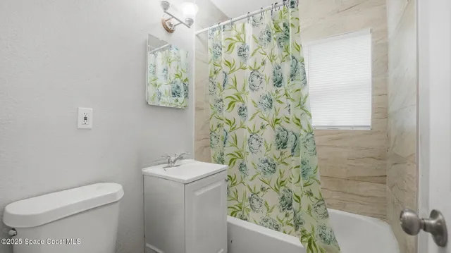 a bathroom with a toilet and a shower curtain