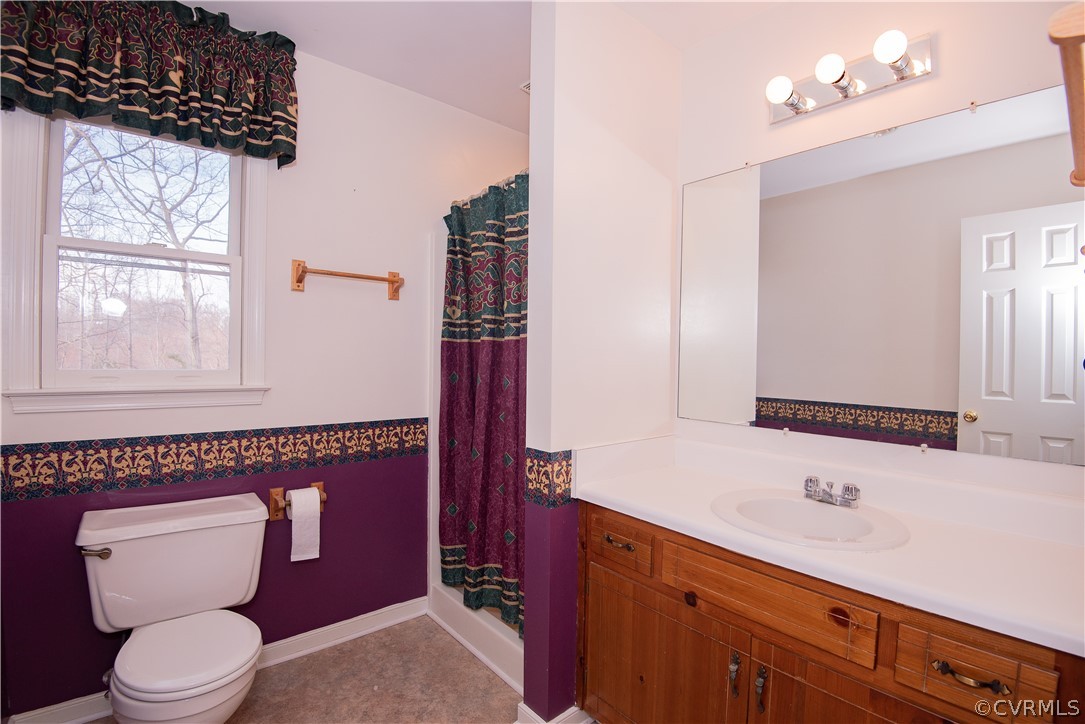 2312 Brookforest Road Midlothian, VA 23112 - Photo 29 of 39 a bathroom with a toilet a sink a mirror and a window