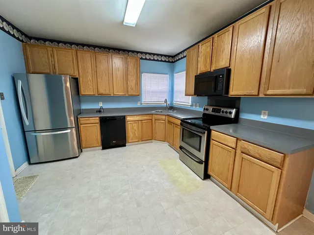 a kitchen with stainless steel appliances granite countertop a refrigerator stove microwave and sink