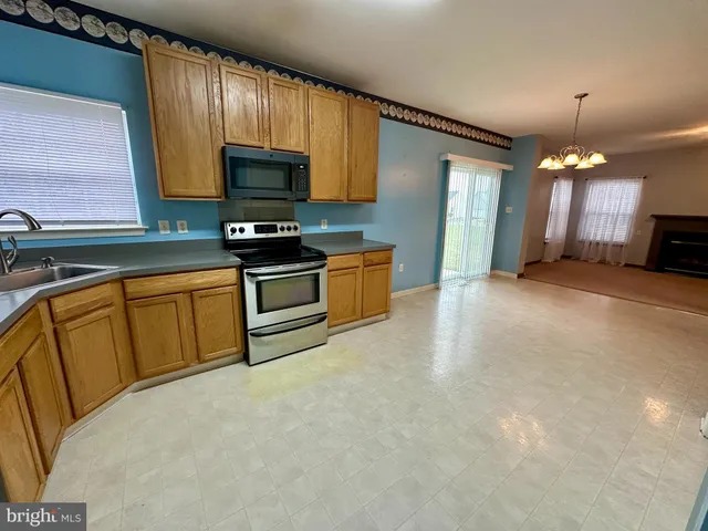 a kitchen with stainless steel appliances granite countertop a stove sink and microwave