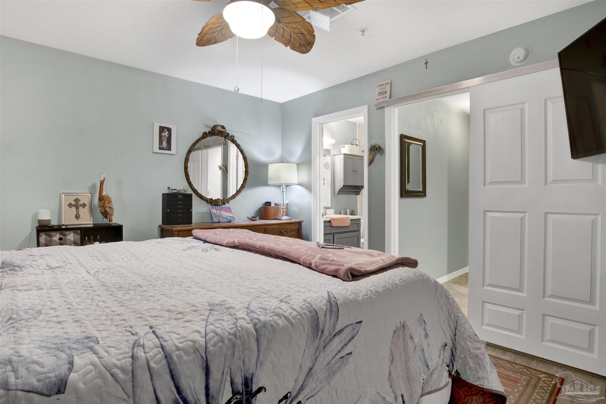 13351 Johnson Beach Road, Unit 203E Perdido Key, FL 32507 - Photo 17 of 55 a bedroom with a bed mirror on dresser and a chandelier