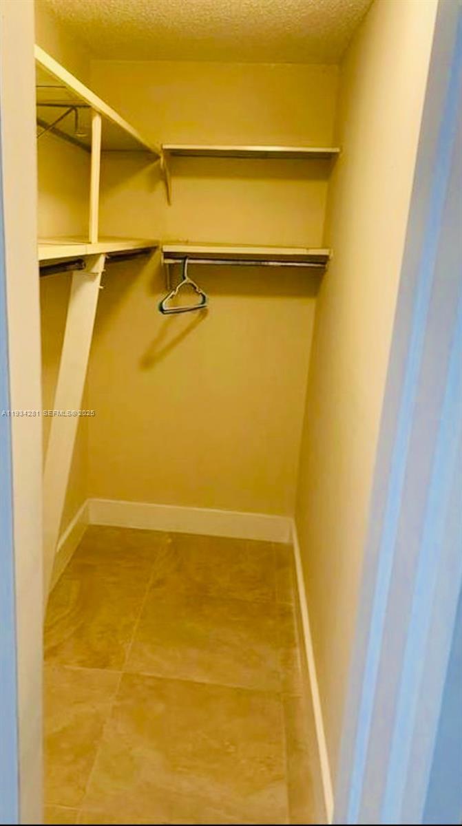 4803 Northwest 7th Street, Unit 21014 Miami, FL 33126 - Photo 5 of 15 a view of walk in closet with empty racks