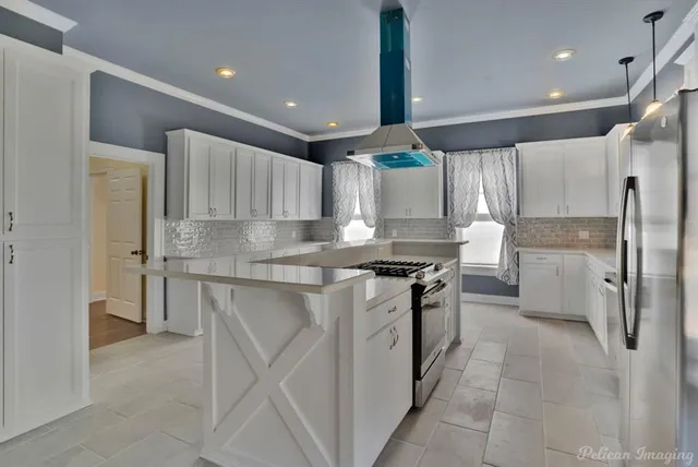 a kitchen with stainless steel appliances granite countertop a stove a sink and a refrigerator