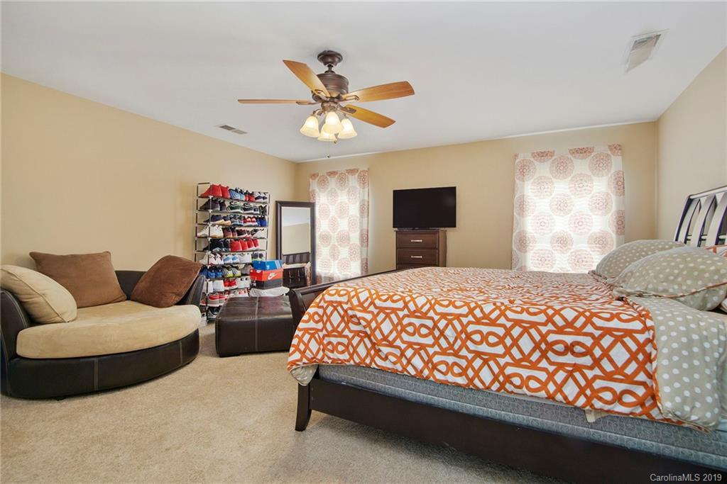 10529 Greenhead View Road Charlotte, NC 28262 - Photo 25 of 32 a bedroom with a bed and a chandelier