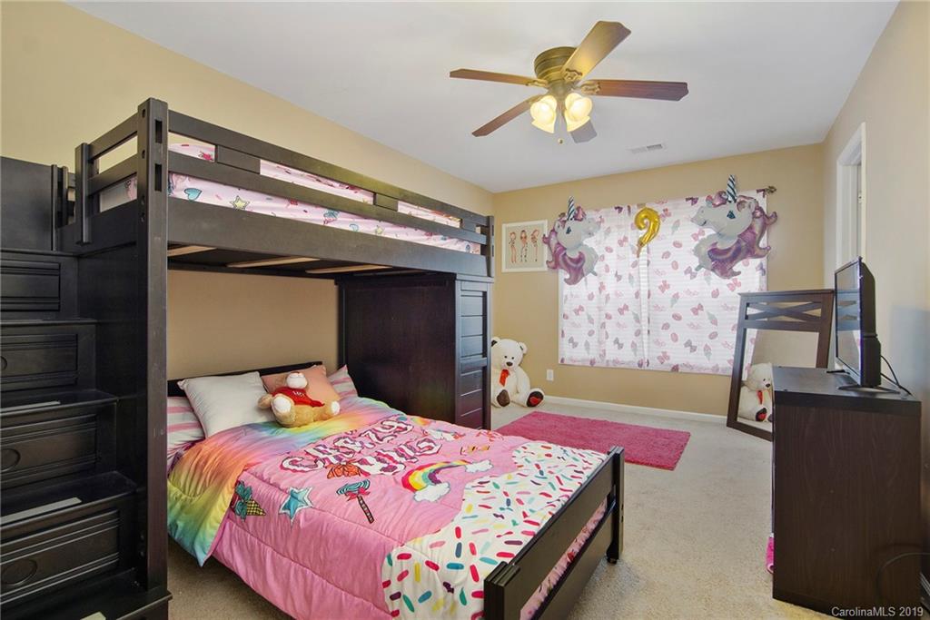 10529 Greenhead View Road Charlotte, NC 28262 - Photo 26 of 32 a bedroom with a bed and a chandelier