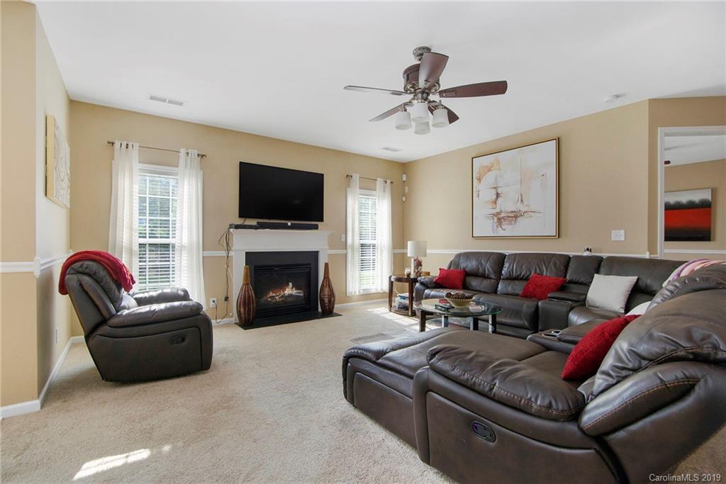10529 Greenhead View Road Charlotte, NC 28262 - Photo 5 of 32 a living room with furniture a flat screen tv and a fireplace