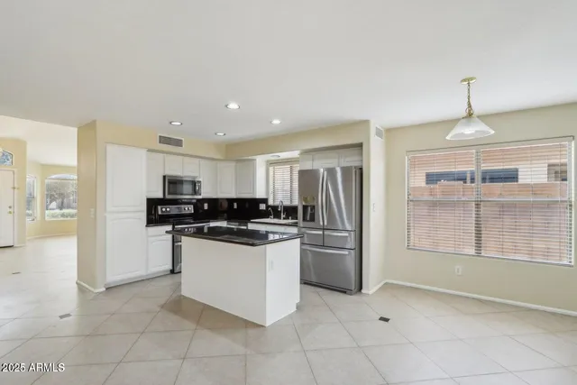 a kitchen with stainless steel appliances granite countertop a refrigerator and a stove top oven