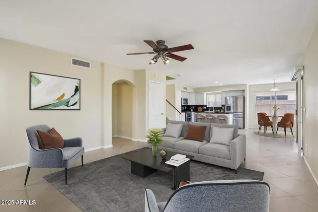a living room with furniture and a view of kitchen