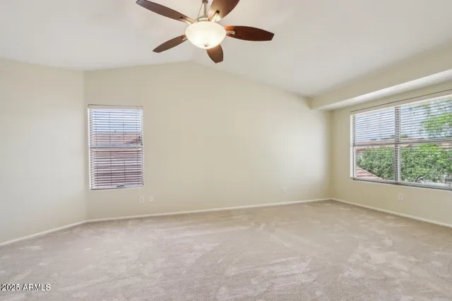 an empty room with windows and fan