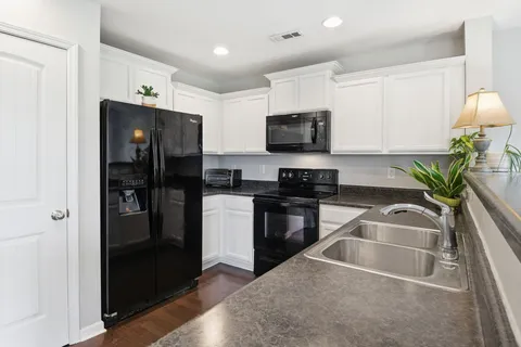 a kitchen with granite countertop a refrigerator and a sink