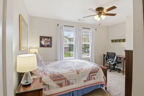 a bedroom with a bed wooden floor and a lamp on table