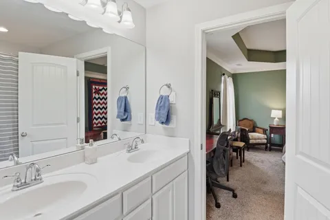 a en suite bathroom with a sink double vanity and a mirror