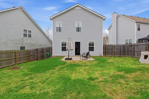 a view of house with backyard and porch