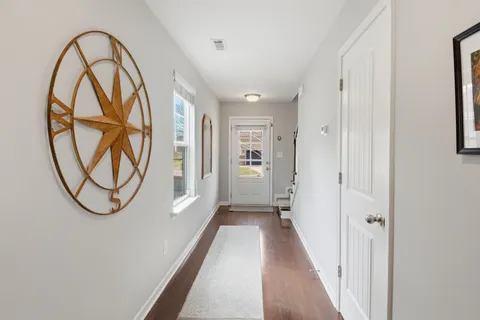 a view of a hallway with wooden floor and a entryway