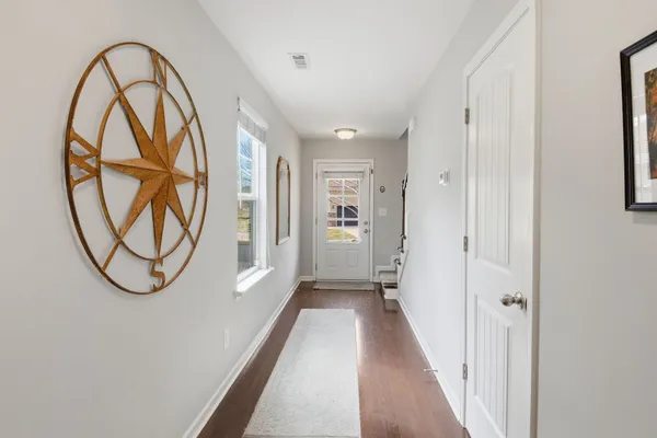 a view of a hallway with wooden floor and a entryway