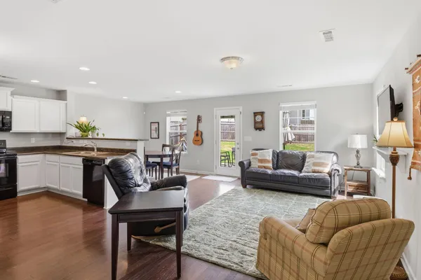 a living room with furniture and a wooden floor